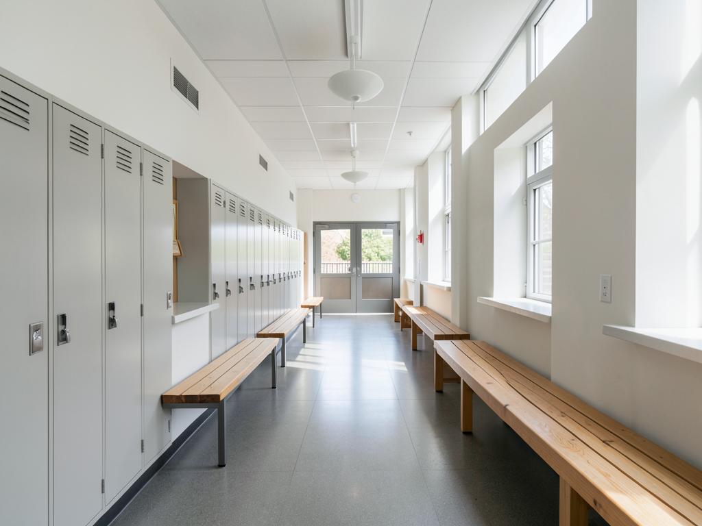 Daylit school corridor with lockers and timber benches